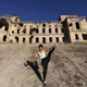 Afghan Bruce Lee poses for the media in front of the destroyed Darul Aman Palace in Kabul.